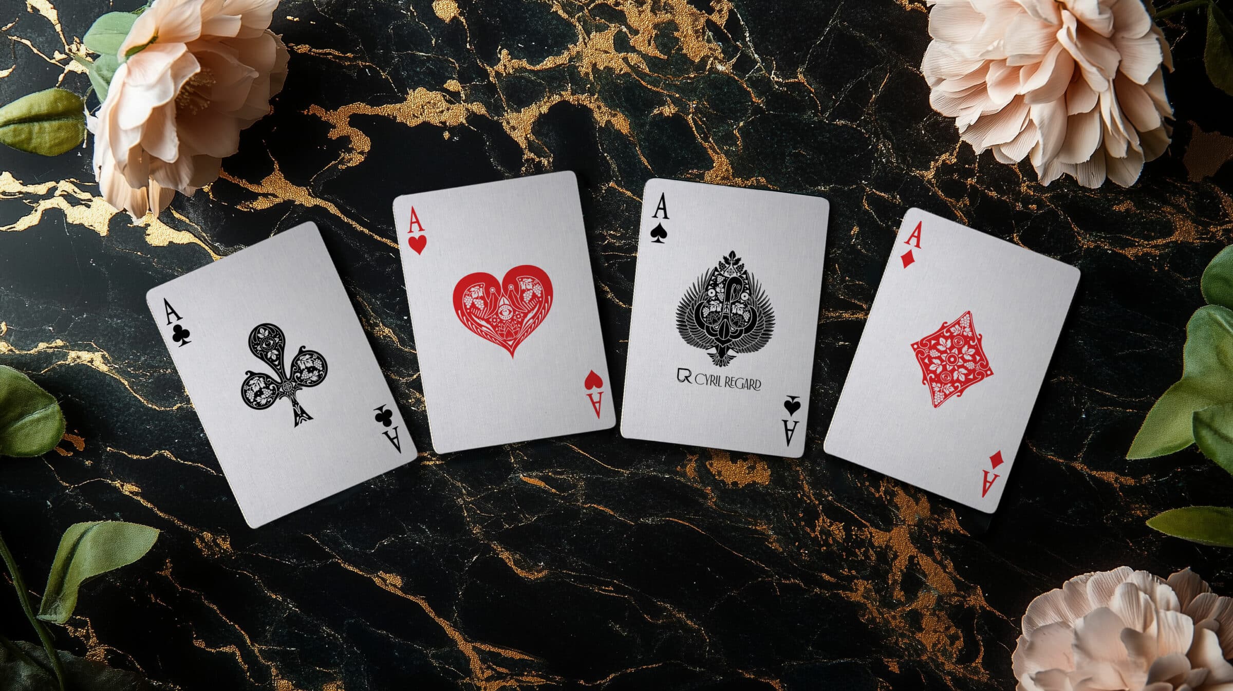 The four aces of Cyril Regard's Flamingo playing cards, on black and gold marble
