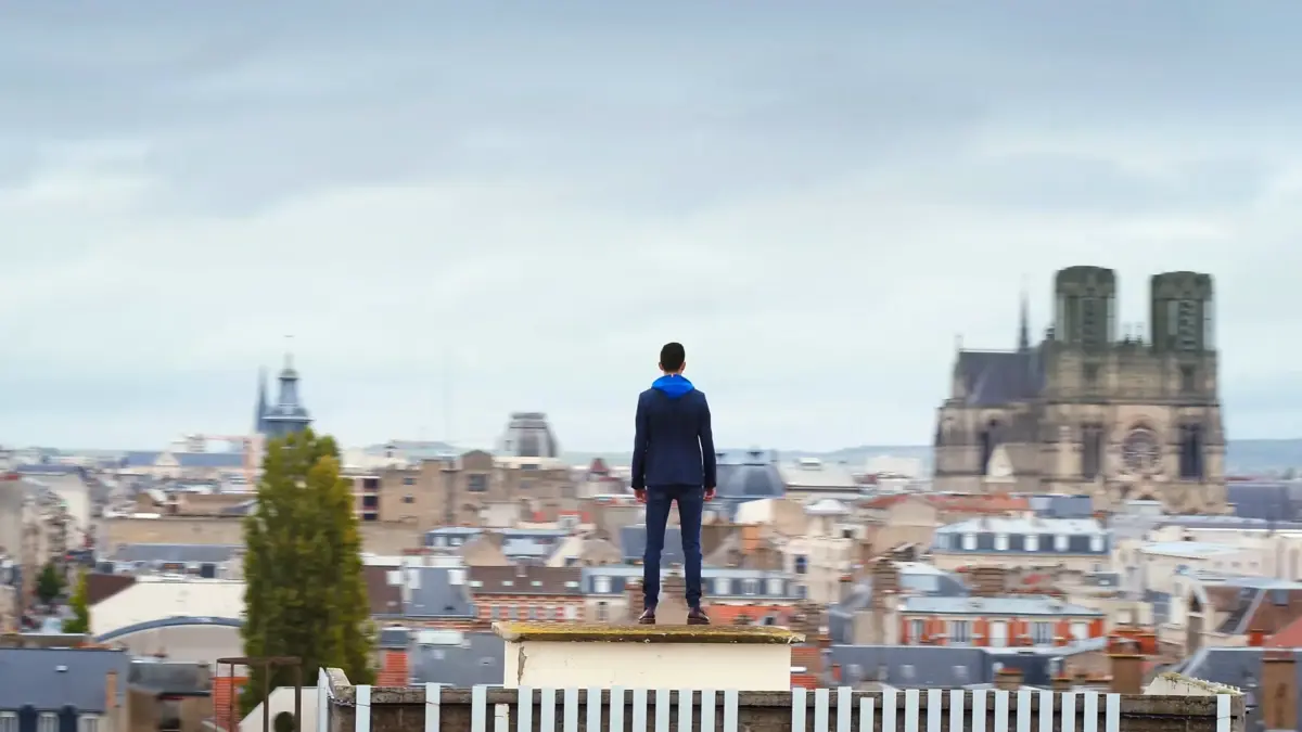 Cyril Regard, de dos sur un toit de Reims, face à la cathédrale