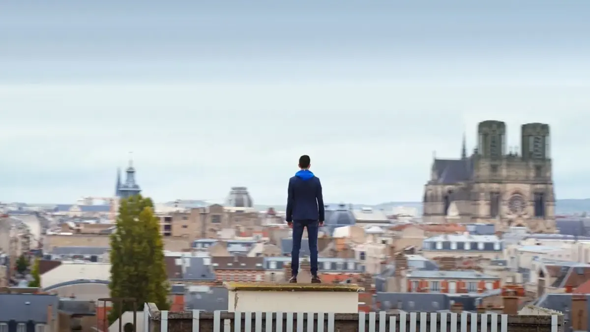 Cyril Regard, de dos sur un toit de Reims, face à la cathédrale